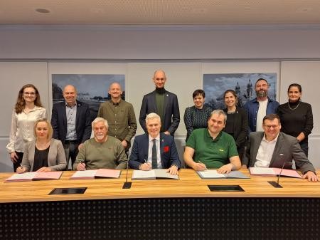 Auf dem Foto sind die Teilnehmer der Vertragsunterzeichnung